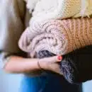 person holding knitted textiles