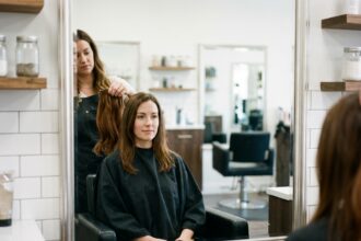 Coiffeuse professionnelle présentant des extensions de cheveux naturels à une cliente dans un salon moderne