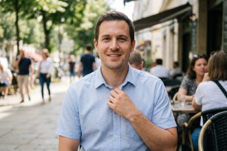 Homme souriant ajustant son col en extérieur