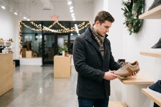 Jeune homme regardant des sneakers dans un magasin moderne