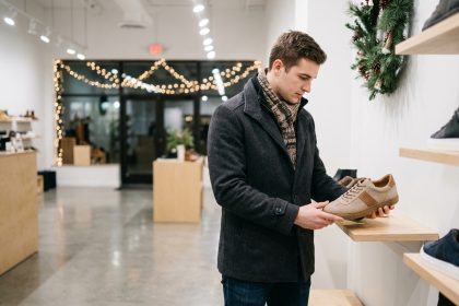 Jeune homme regardant des sneakers dans un magasin moderne