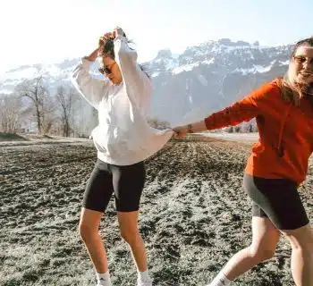 woman in white shirt and black shorts standing on rocky ground during daytime