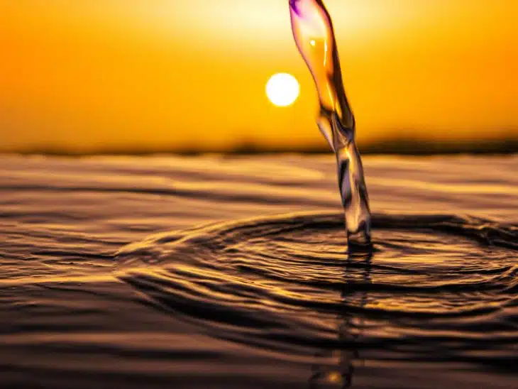 water drop on brown sand during sunset