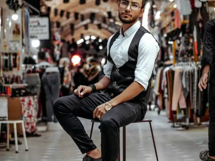 man in white and black polo shirt and black pants sitting on chair